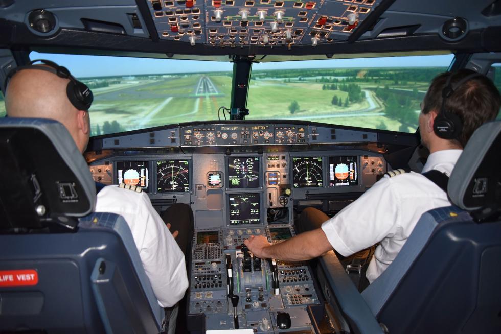Two pilots in the cockpit landing a plane