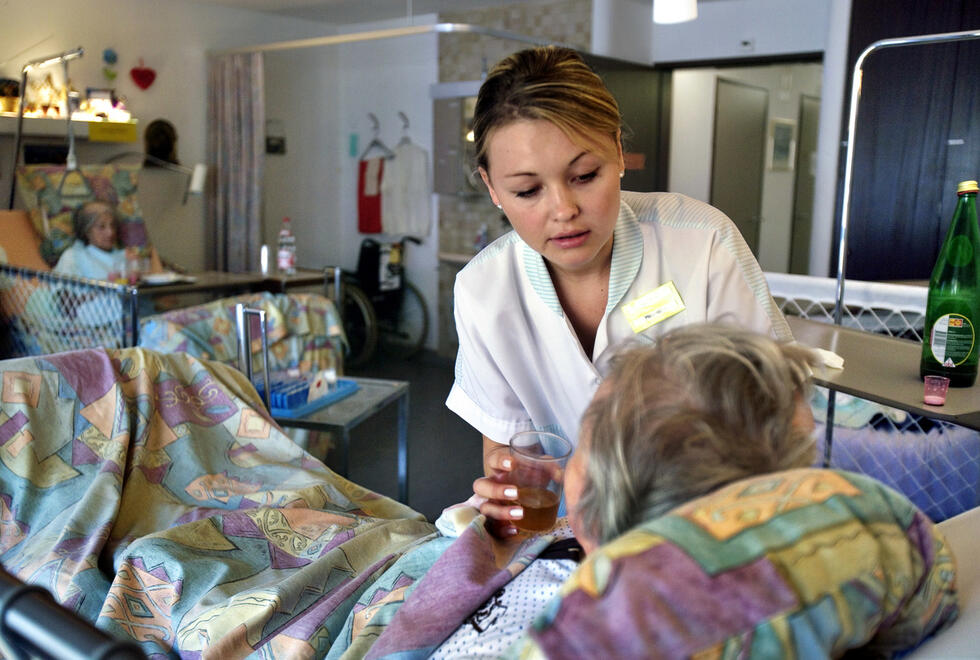 A carer looks after an elderly woman